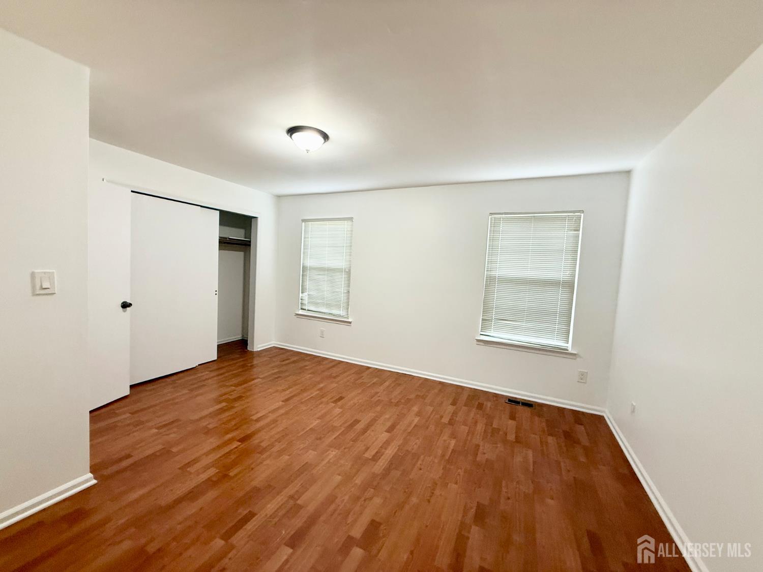 405 Maplecrest Road Edison, NJ 08820 - Photo 13 of 13 a view of an empty room with wooden floor and a window