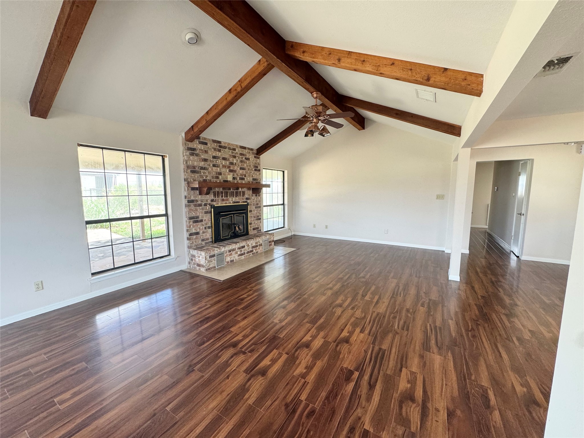 18512 Carlson Lane Elgin, TX 78621 - Photo 4 of 29 Gleaming wood floors anchor a spacious living area detailed with a classic brick fireplace.