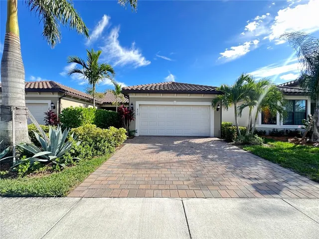 a front view of a house with a yard and potted plants