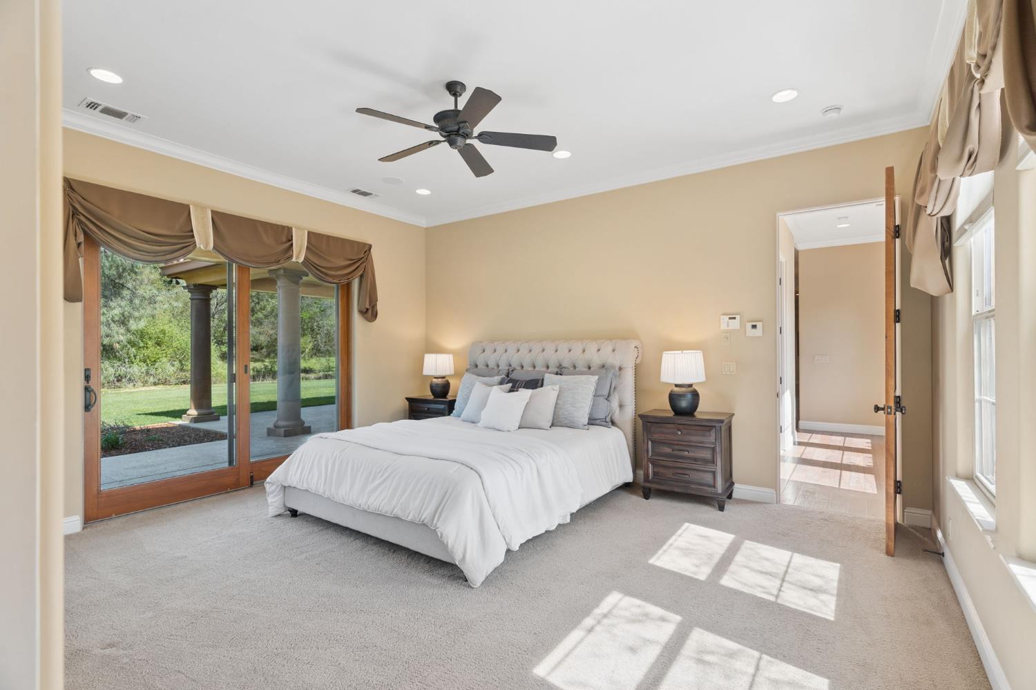 5180 Remuda Court Shingle Springs, CA 95682 - Photo 29 of 88 a spacious bedroom with a large bed and a chandelier