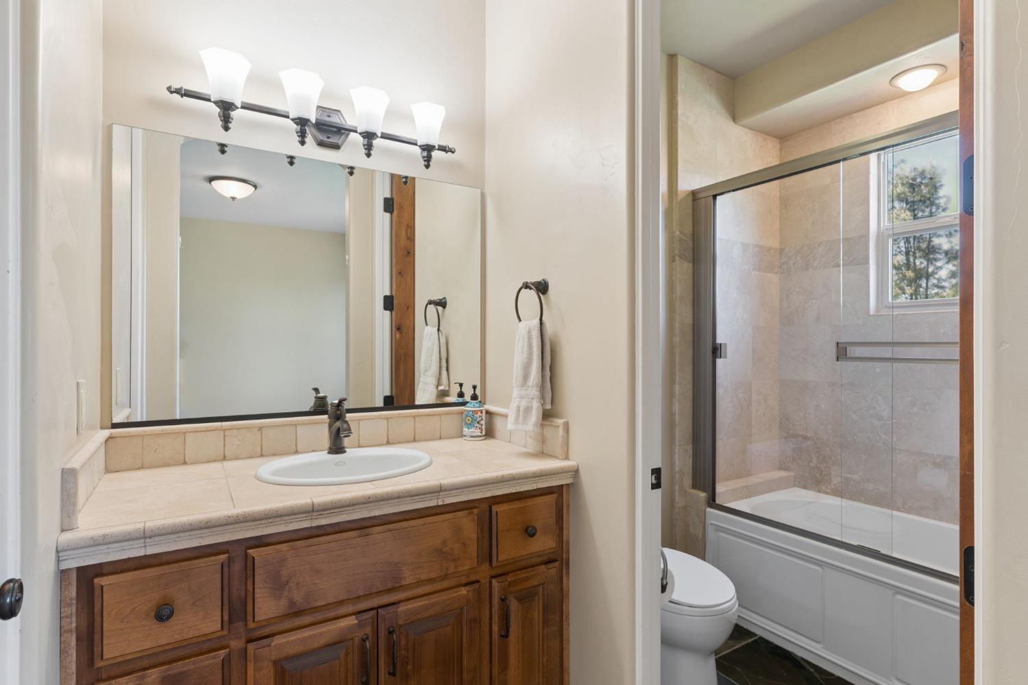 5180 Remuda Court Shingle Springs, CA 95682 - Photo 54 of 88 a bathroom with a granite countertop sink toilet and shower