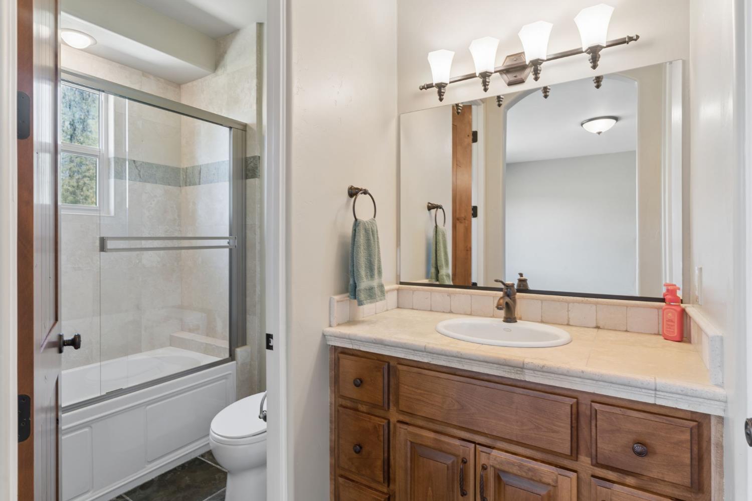 5180 Remuda Court Shingle Springs, CA 95682 - Photo 57 of 88 a bathroom with a granite countertop sink toilet and shower