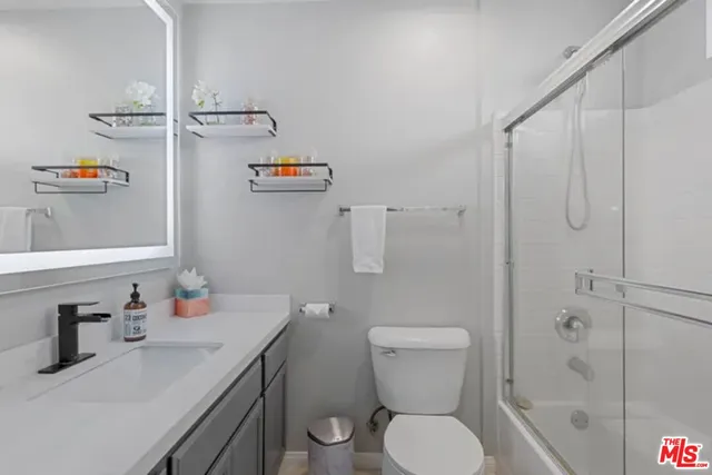a bathroom with a sink vanity granite and toilet