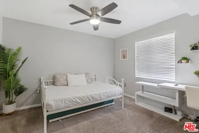 a bedroom with a bed and a potted plant