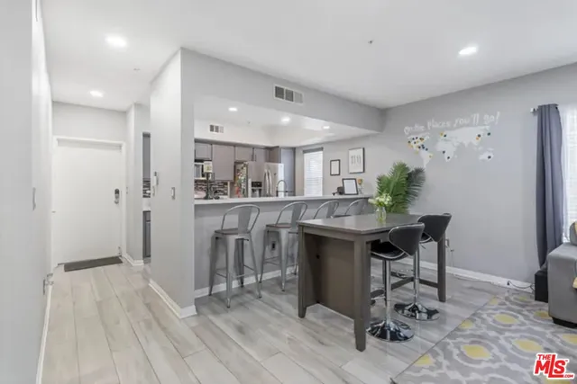 a kitchen with stainless steel appliances granite countertop a refrigerator and a wooden cabinets