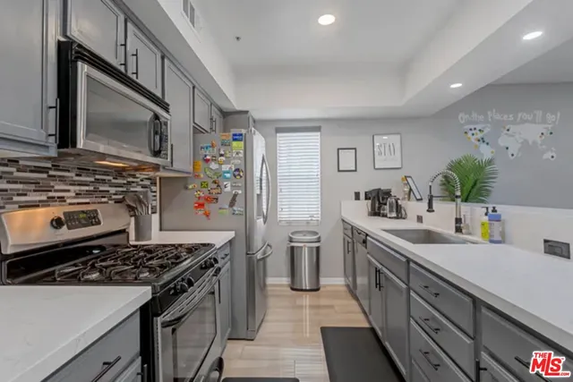 a kitchen with stainless steel appliances a sink dishwasher stove and oven