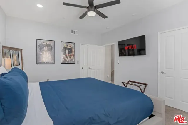 a bedroom with a bed and a flat screen tv