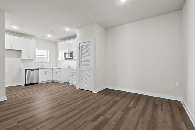 a view of a kitchen with wooden floor and electronic appliances