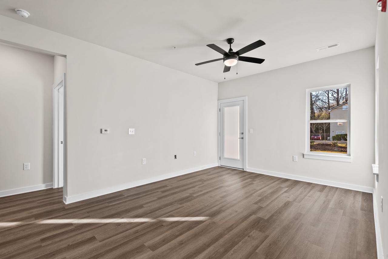 223 South Eleventh Street, Unit 103 Mebane, NC 27302 - Photo 13 of 41 a view of an empty room with a window and wooden floor