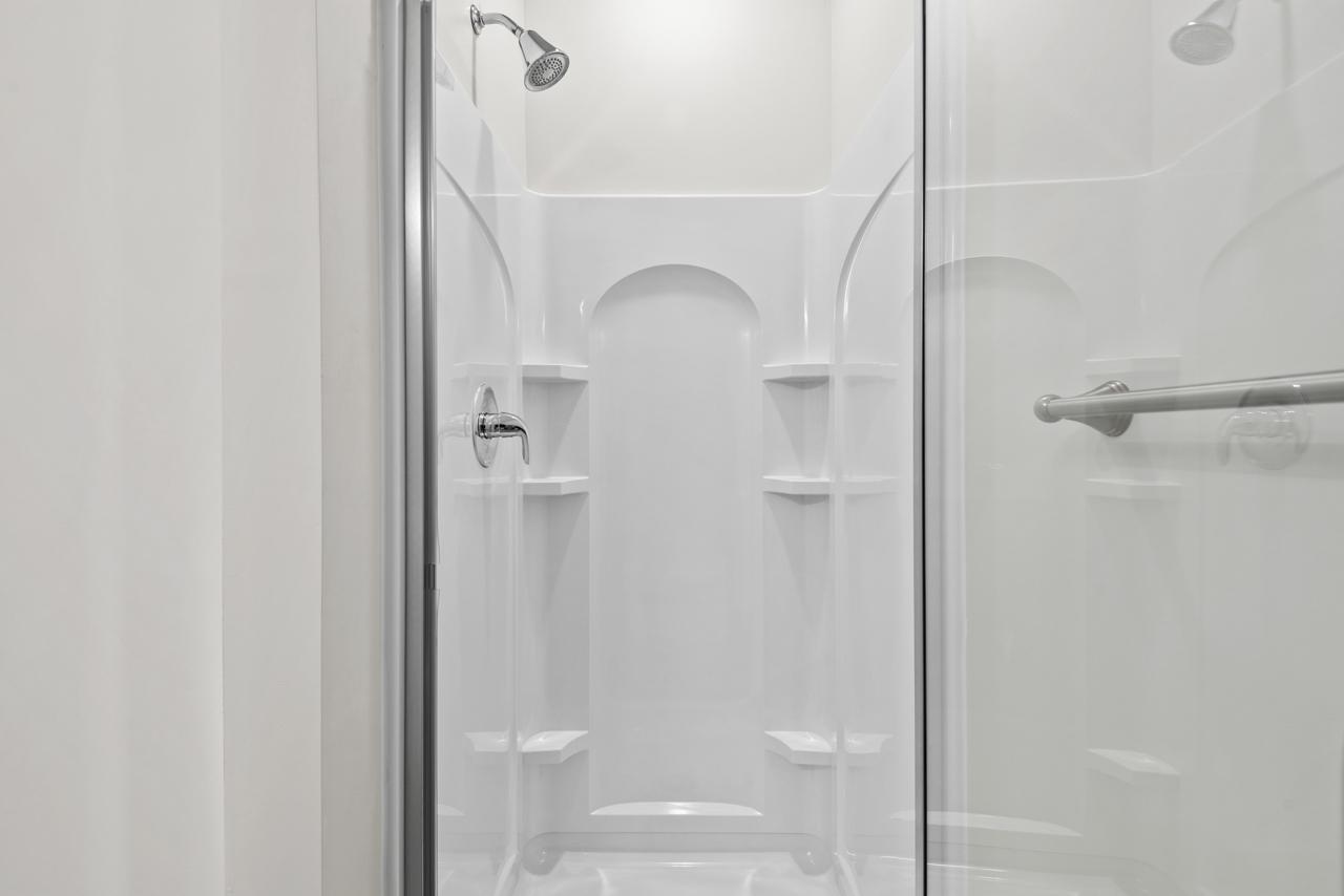 223 South Eleventh Street, Unit 103 Mebane, NC 27302 - Photo 16 of 41 a bathroom with a glass shower door