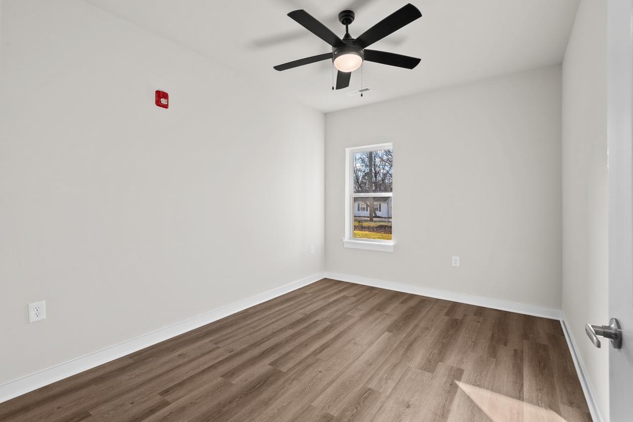 223 South Eleventh Street, Unit 103 Mebane, NC 27302 - Photo 23 of 41 an empty room with a window and a ceiling fan