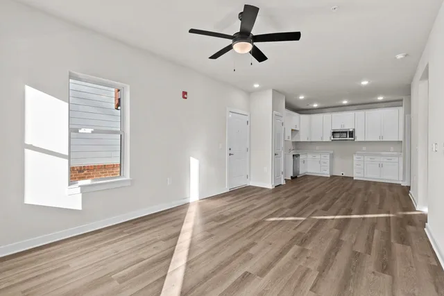 a view of an empty room with kitchen appliances and a window