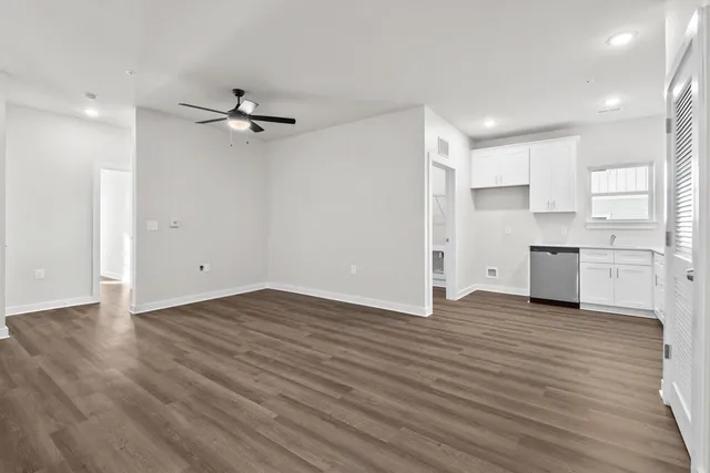 a view of empty room with wooden floor and windows