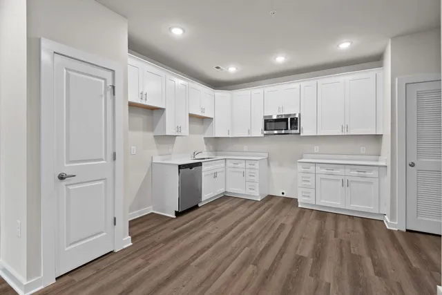 a kitchen with white cabinets and stainless steel appliances