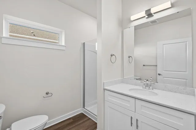 a bathroom with a sink a toilet a shower and a mirror