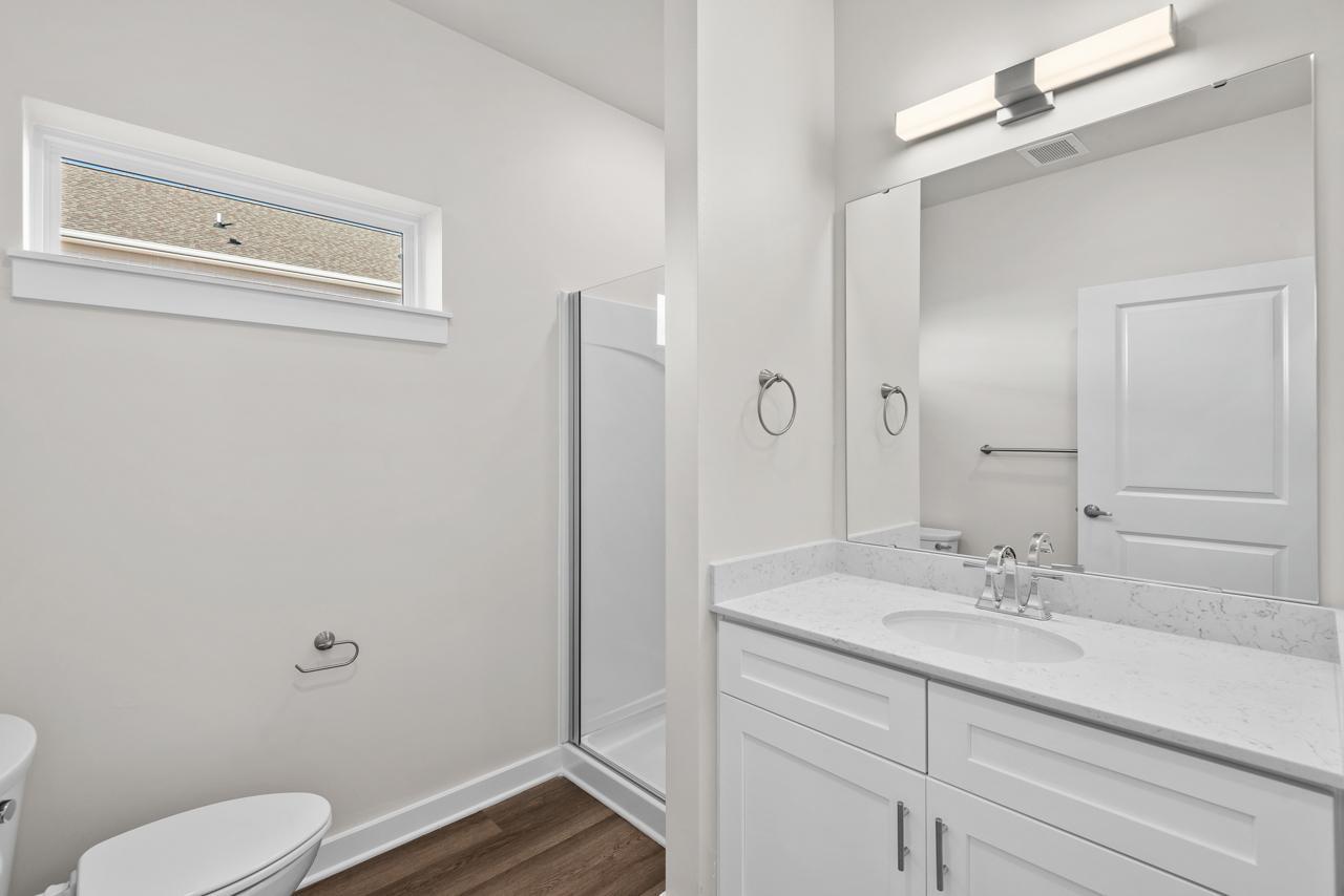 223 South Eleventh Street, Unit 103 Mebane, NC 27302 - Photo 8 of 41 a bathroom with a sink a toilet a shower and a mirror