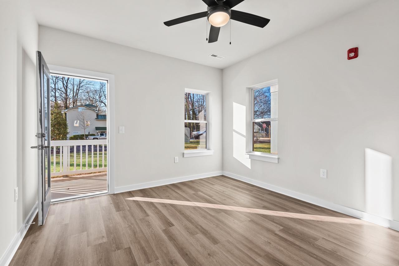 223 South Eleventh Street, Unit 103 Mebane, NC 27302 - Photo 10 of 41 a view of an empty room with a window and wooden floor