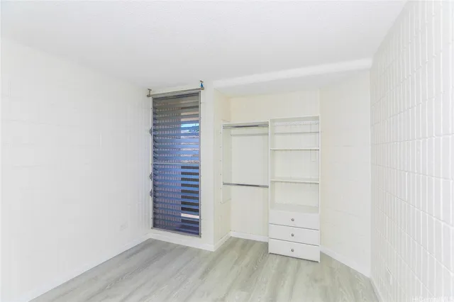 a view of walk in closet with empty racks
