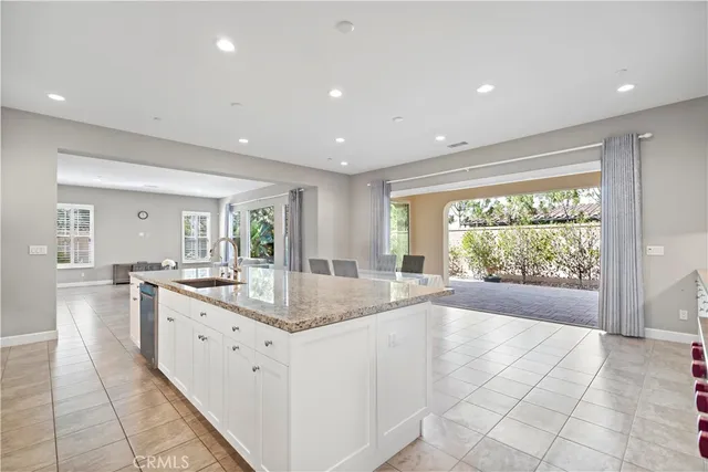 a large kitchen with dining table chairs and view living room