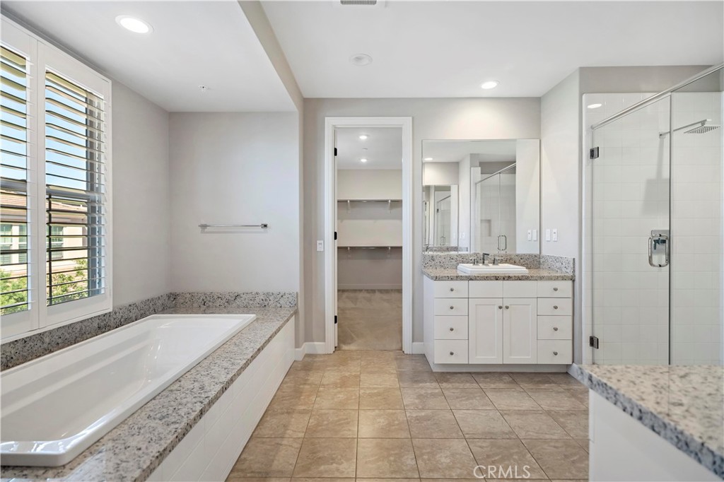 121 Paxton Irvine, CA 92620 - Photo 43 of 61 a spacious bathroom with a granite countertop tub sink and mirror