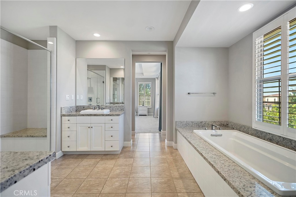 121 Paxton Irvine, CA 92620 - Photo 45 of 61 a spacious bathroom with a granite countertop tub sink and mirror