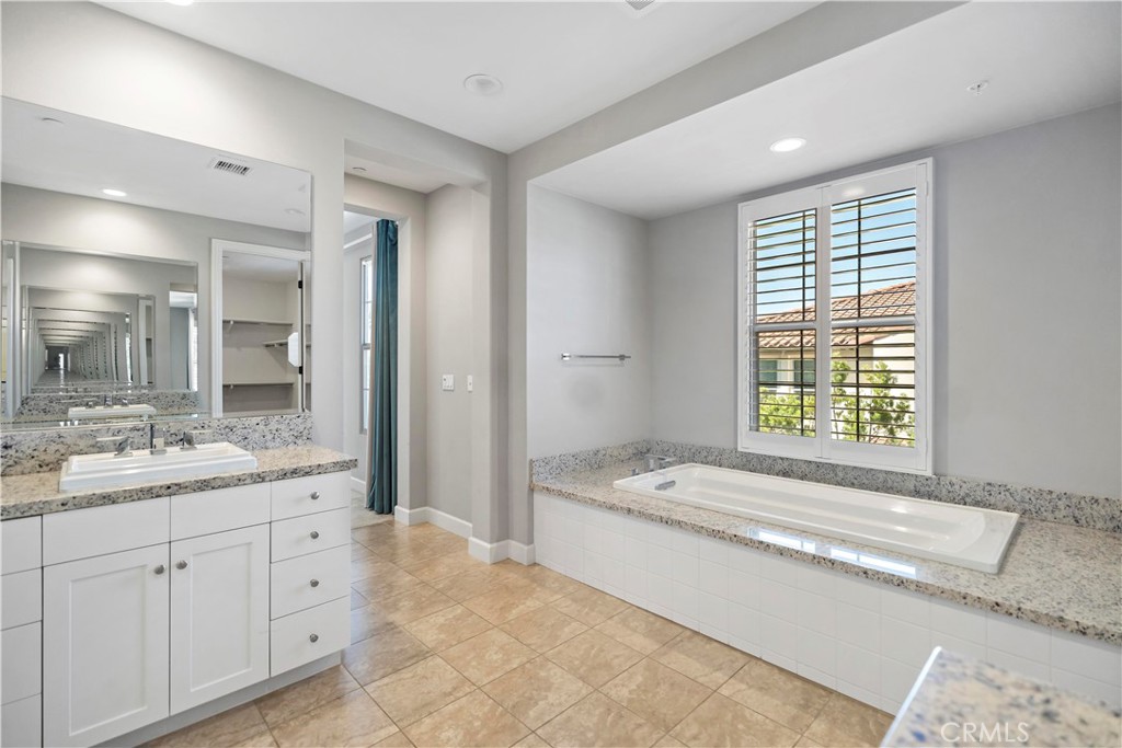 121 Paxton Irvine, CA 92620 - Photo 48 of 61 a spacious bathroom with a granite countertop tub sink and mirror