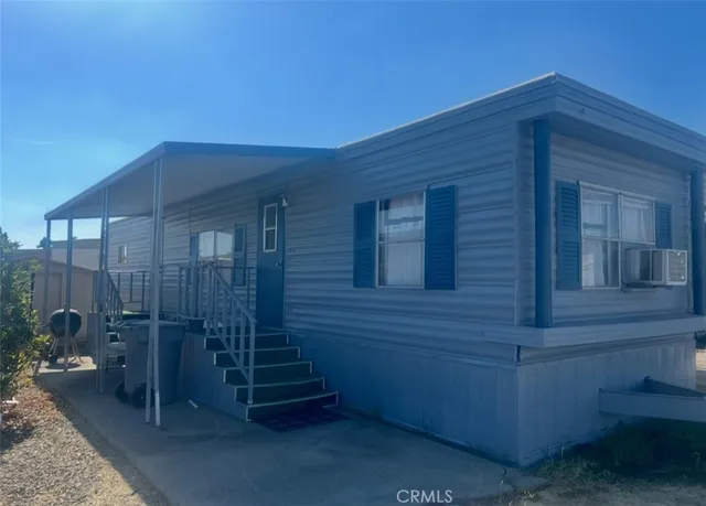 a backyard of a house with barbeque oven and outdoor seating