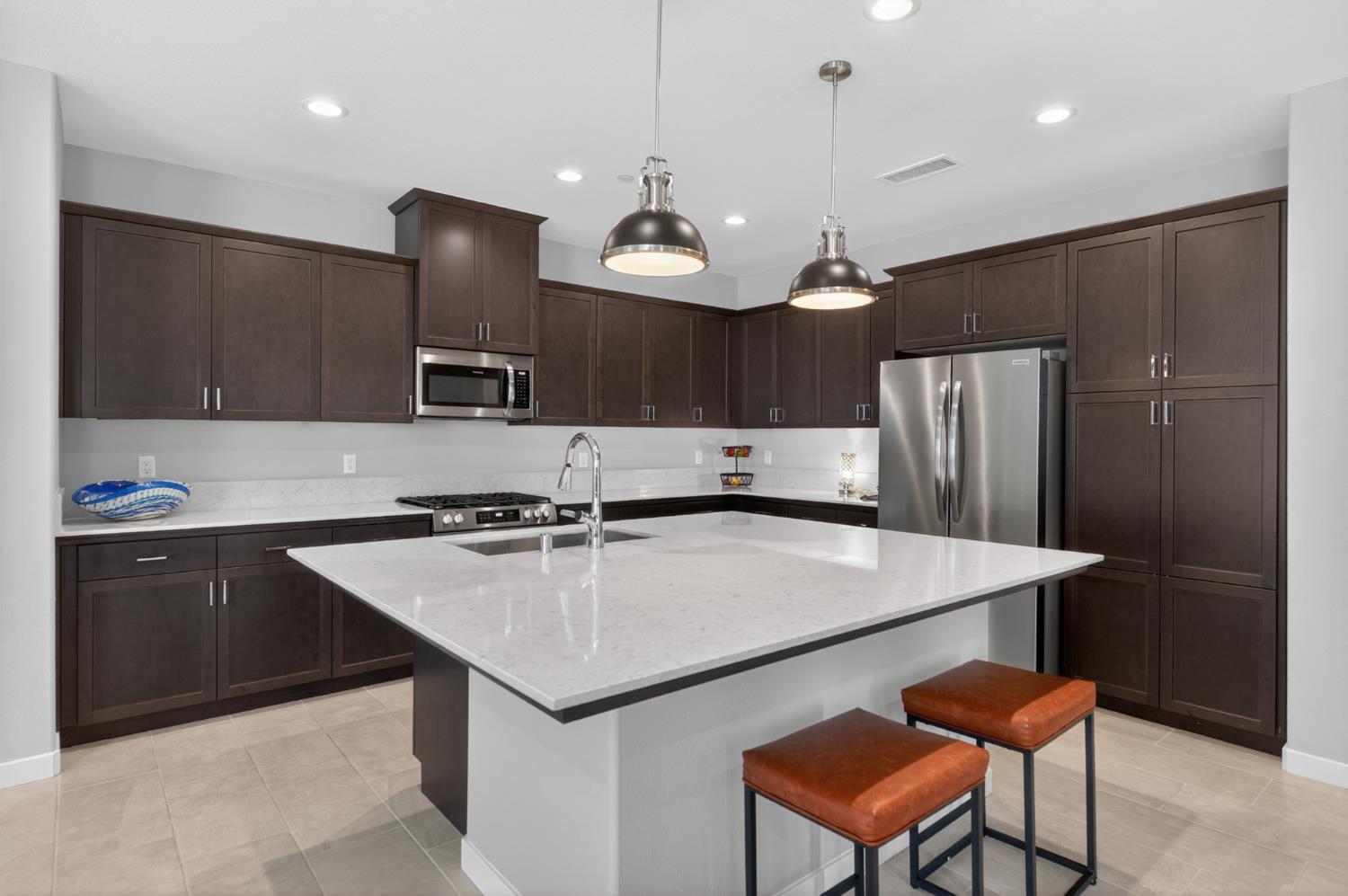 4185 Ryan Lane Madera, CA 93636 - Photo 23 of 63 a kitchen with stainless steel appliances granite countertop a table chairs sink refrigerator and microwave