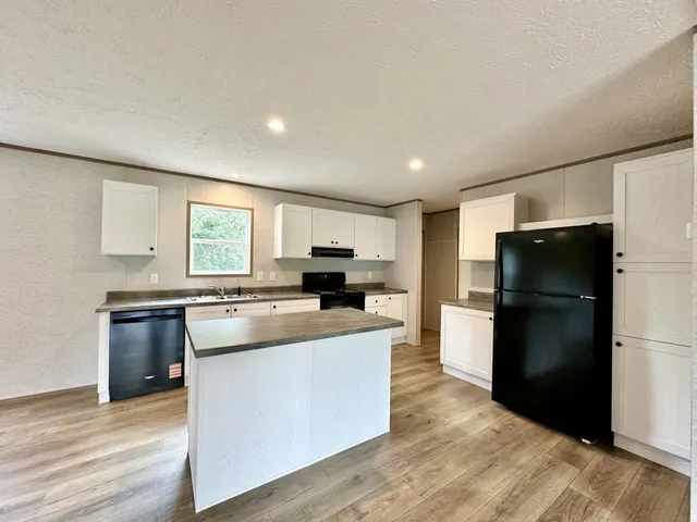 a kitchen with refrigerator and cabinets