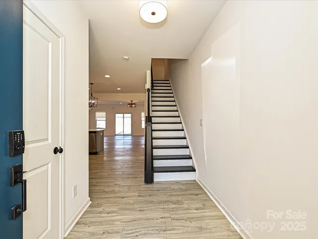 a view of a hallway with wooden floor and staircase