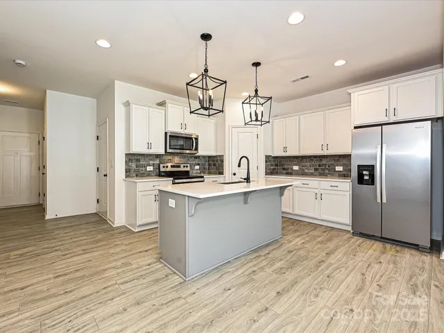 a kitchen with stainless steel appliances a refrigerator sink and microwave
