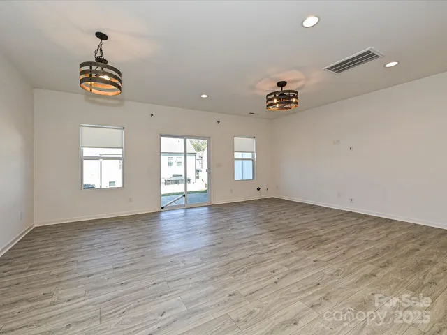 a view of a kitchen with a sink and dishwasher a stove top oven with wooden floor