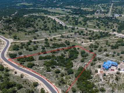 an aerial view of a house with a yard and street