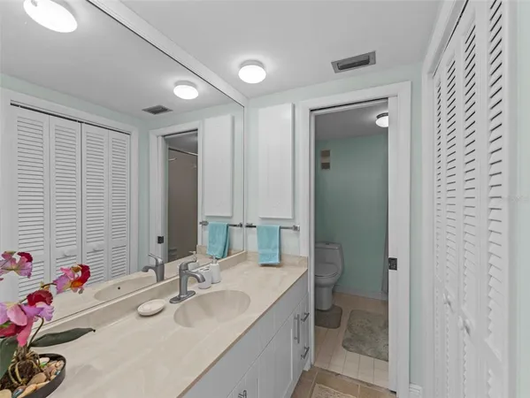 a bathroom with a granite countertop sink mirror and a toilet