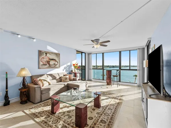 a living room with furniture a flat screen tv and a large window