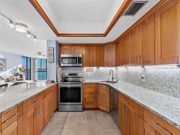 a large kitchen with stainless steel appliances granite countertop a stove sink and cabinets
