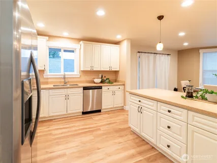 a kitchen with white cabinets stainless steel appliances and sink
