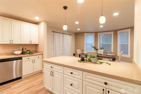 a view of a kitchen with kitchen island a sink stainless steel appliances and cabinets