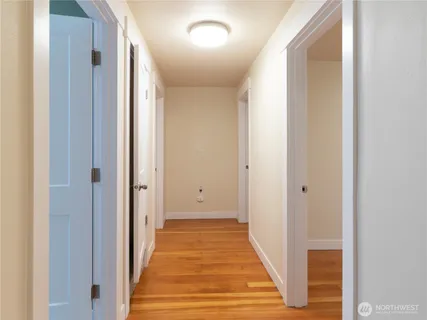 a view of a hallway with wooden floor