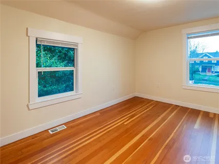 a view of a room with wooden floor and a window