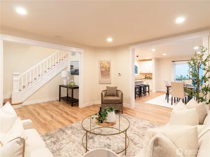 a living room with furniture and a dining table with wooden floor