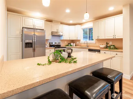 a kitchen with stainless steel appliances kitchen island granite countertop a sink and cabinets