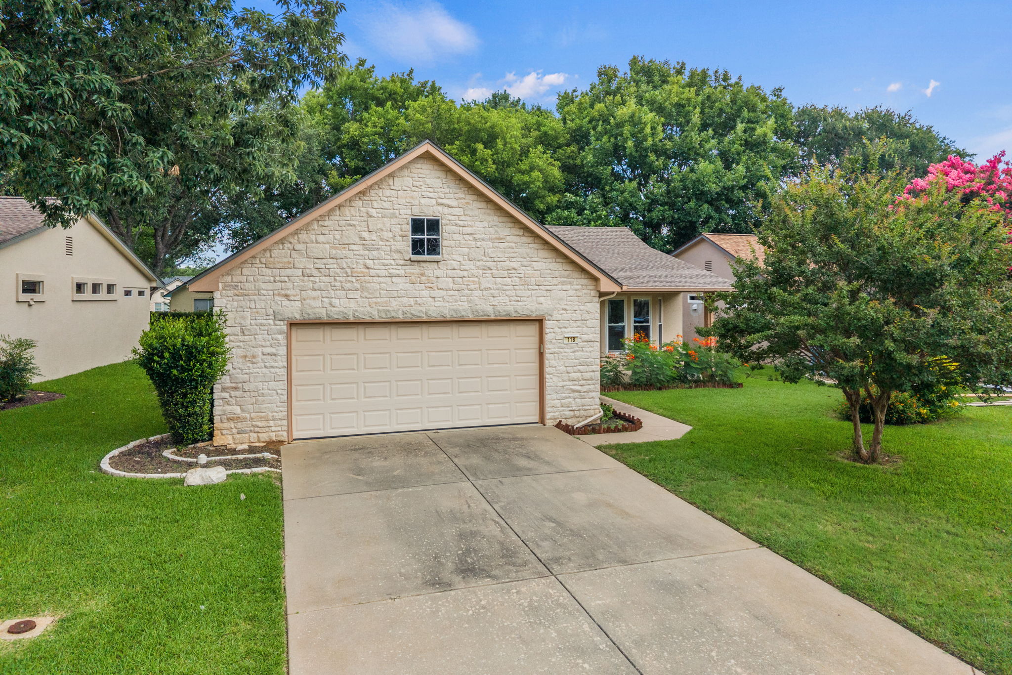 118 Bass Street Georgetown, TX 78633 - Photo 36 of 40 A welcoming stone facade with an integrated garage and a well-maintained yard greets visitors.
