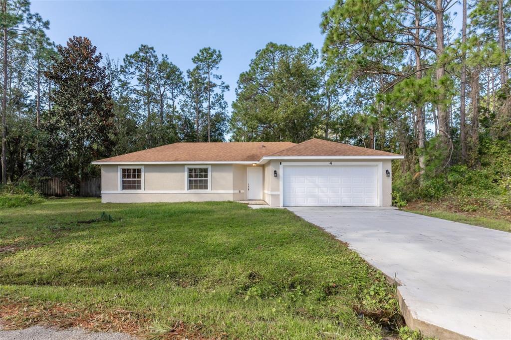 4 Slidell Place Palm Coast, FL 32164 - Photo 1 of 1 a view of a yard in front of a house with large trees