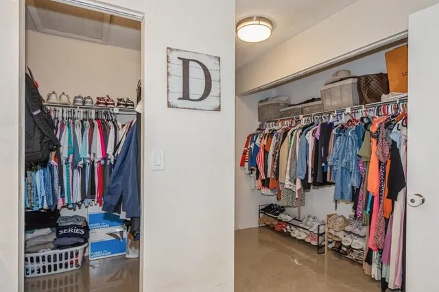 a view of walk in closet with clothes