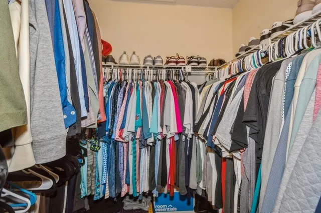 a view of walk in closet with clothes
