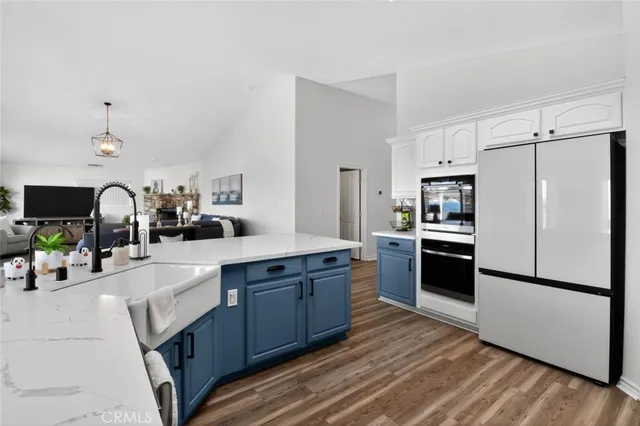a kitchen with stainless steel appliances a sink cabinets and wooden floor
