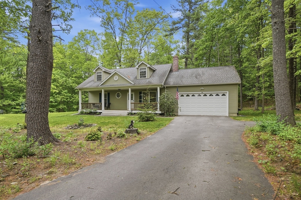 186 Common Street Groton, MA 01450 - Photo 1 of 28 a front view of a house with a garden