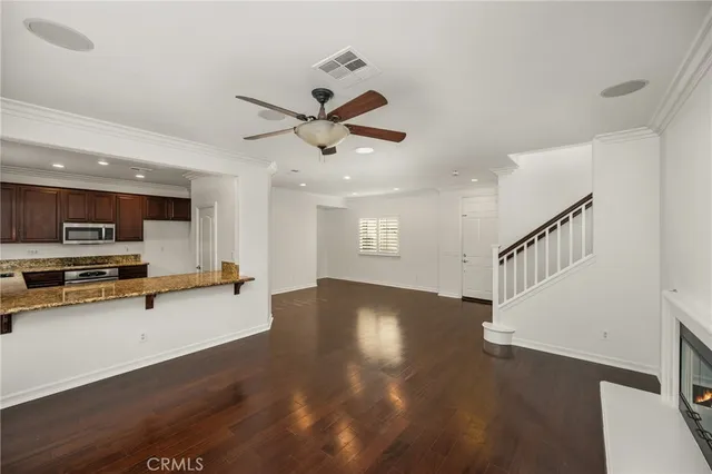 a view of a livingroom with wooden floor and a ceiling fan
