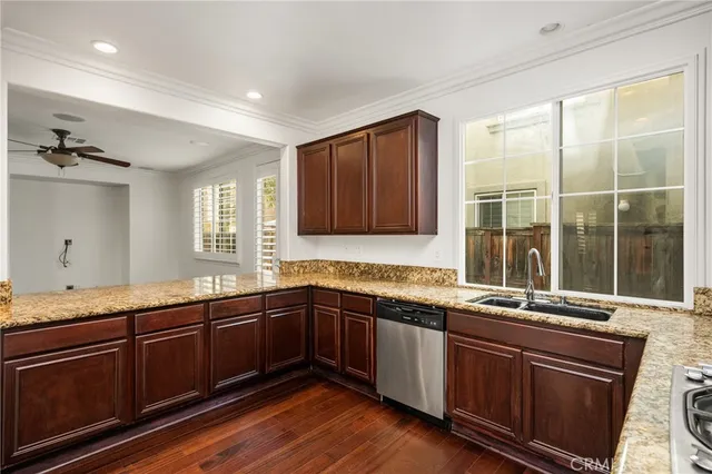 a kitchen with stainless steel appliances granite countertop a sink and wooden cabinets